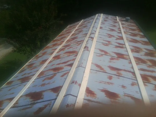 Rusted metal roof panels with new wood purlins before replacement — Storm Damage Roof Repair in Greenlawn by Roofing Brothers