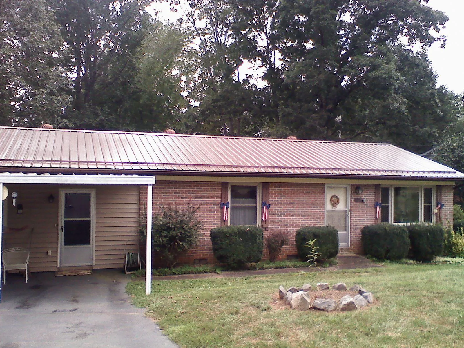 Bronze metal roof and carport on a brick ranch home — Roof Repair work by our crew in Greenlawn