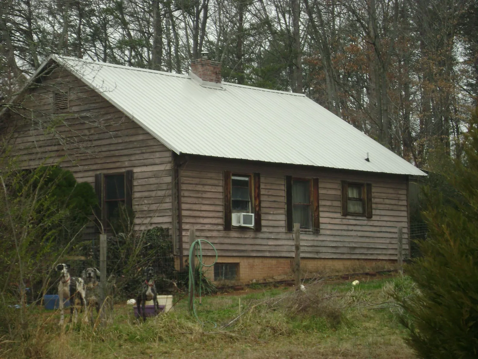 White metal roof on an old wood sided farmhouse, from a Metal Roof Installation job in Greenlawn